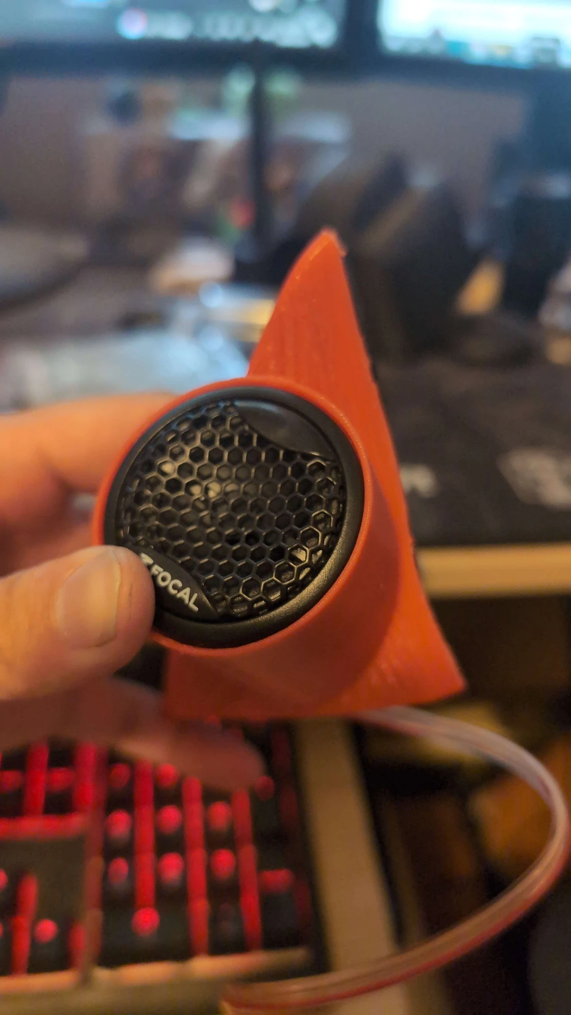 Orange printed tweeter pod with a Focal speaker inserted, photographed on the workbench.